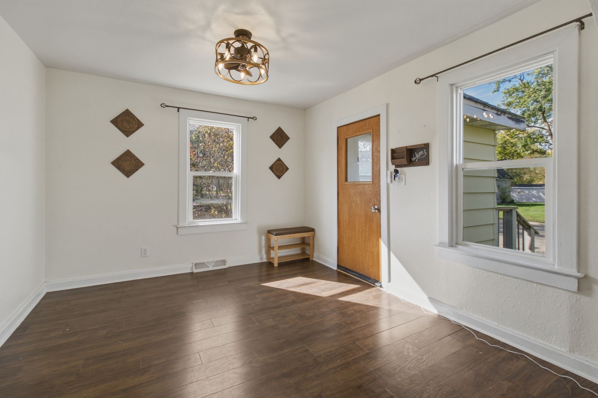 Sunlit entry room with wood floors